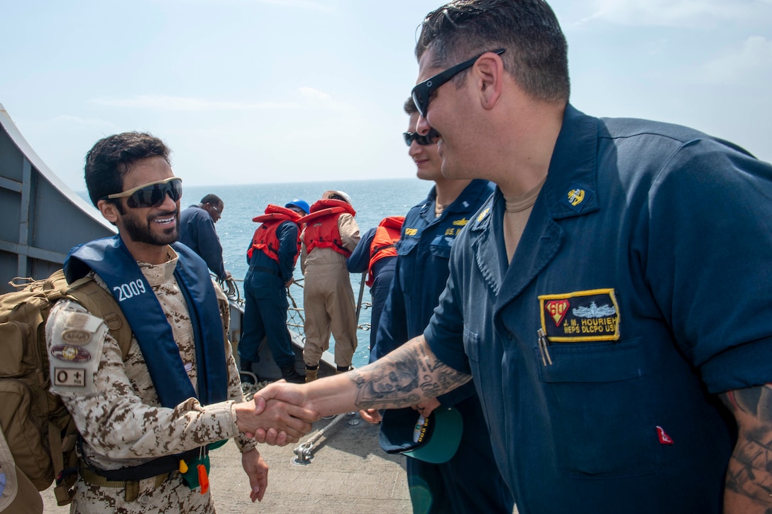 230226-N-NH267-1092 ARABIAN GULF (Feb. 26, 2023) Chief Gunner’s Mate Joseph Hourieh and Bahrain Defence Force Maj. Manjoor Ali Alkhldi shake hands aboard guided-missile destroyer USS Paul Hamilton (DDG 60) in the Arabian Gulf, Feb. 26, 2023. Paul Hamilton is deployed to the U.S. 5th Fleet area of operations to help ensure maritime security and stability in the Middle East region.