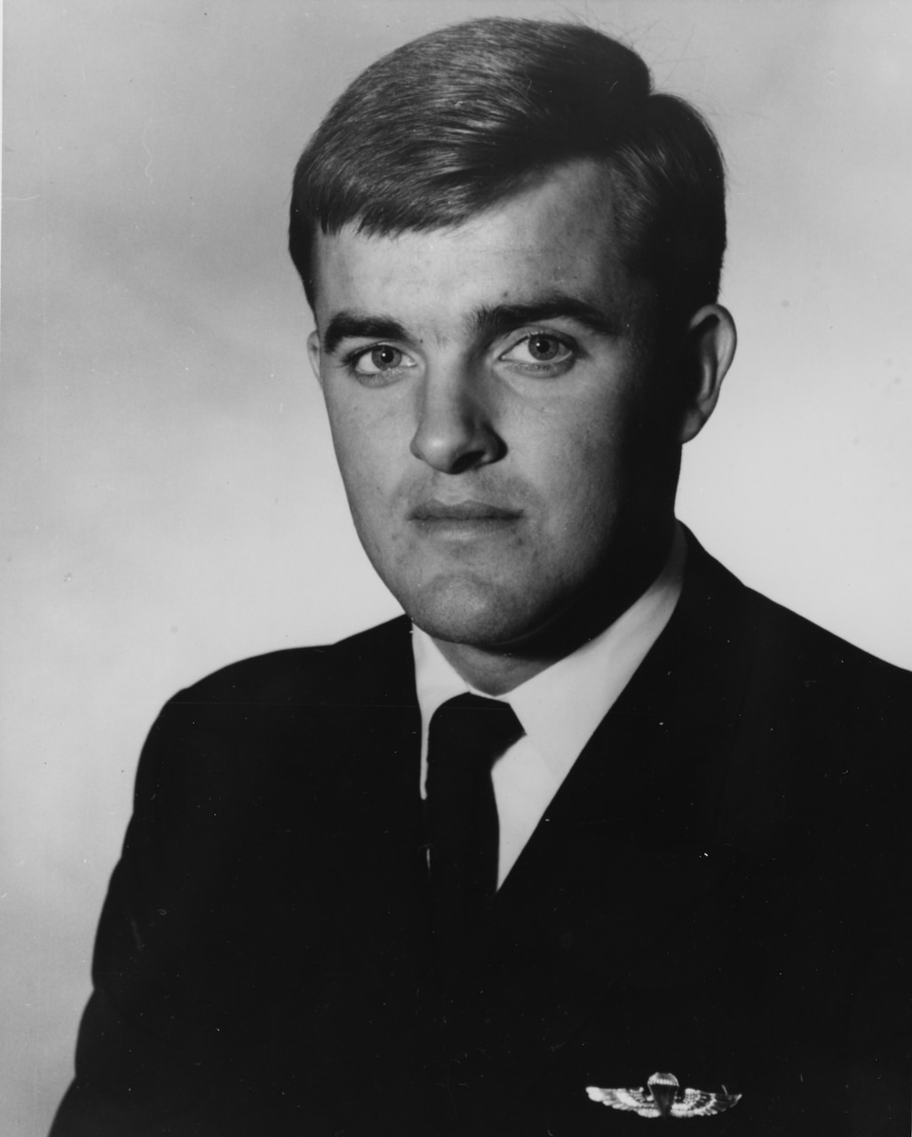 A man in suit and tie poses for a photo.