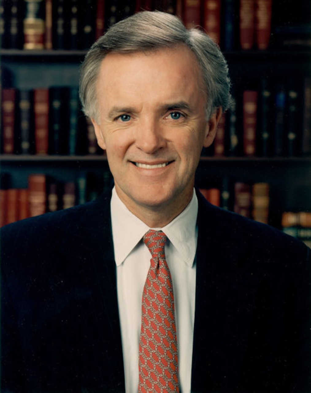 A man in suit and tie poses for a photo.