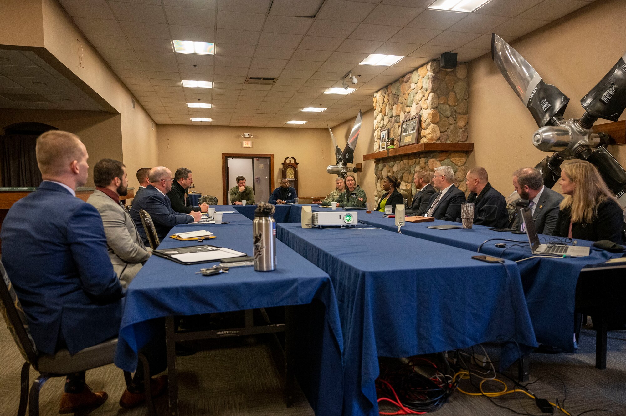 A group of people are sat discussing at a conference table