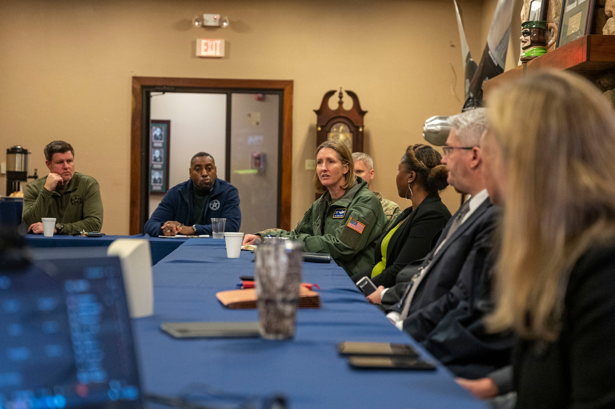 A group of people are sat discussing at a conference table