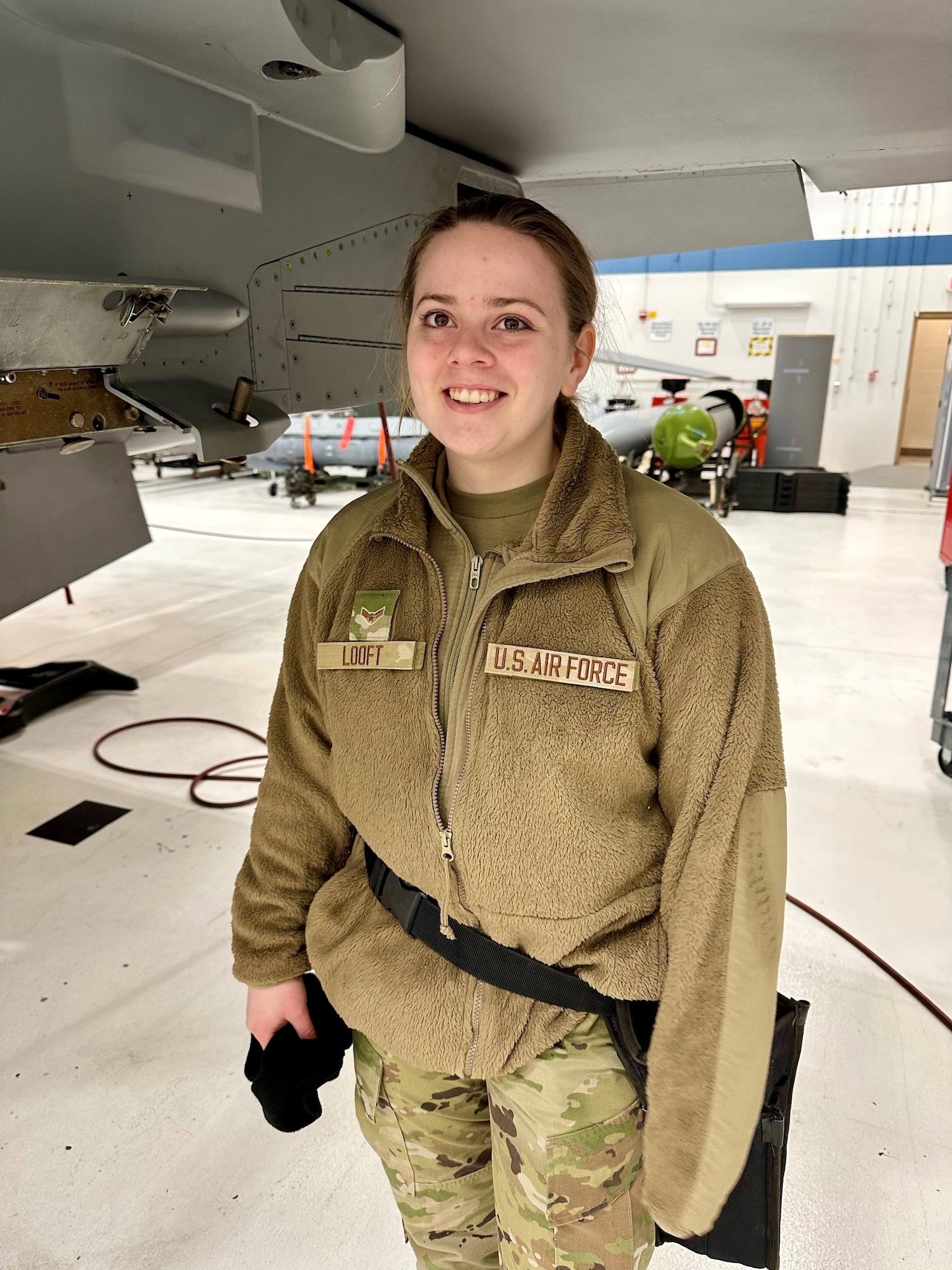 U.S. Air National Guard aircraft armament systems specialist, Airman 1st Class Cress Looft poses for a photo by an F-16 Fighting Falcon assigned to the 148th Fighter Wing, Minnesota Air National Guard, on February 25, 2023. Looft is one of seven airmen assigned to the 148th Fighter Wing who earned the highest possible ASVAB AFQT score of 99.