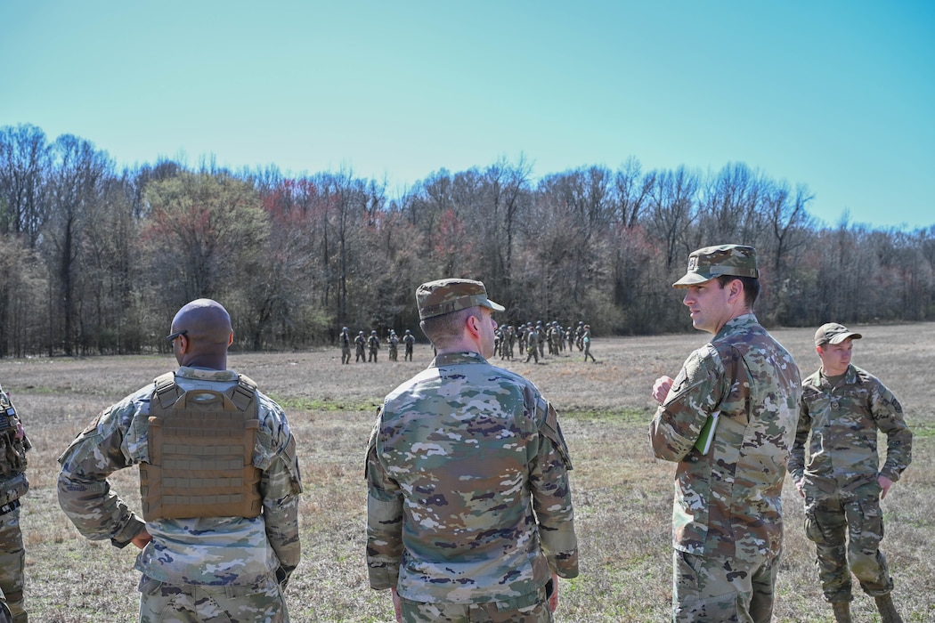 People in uniform stand in a field together