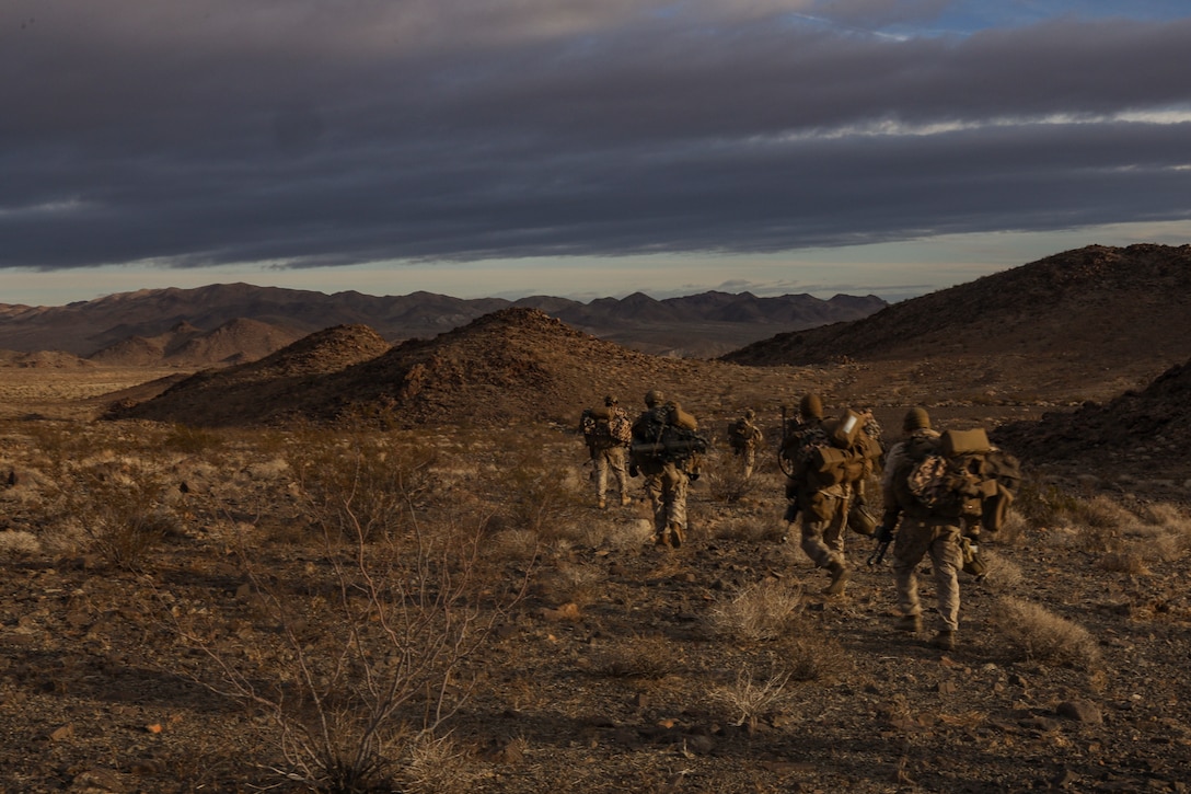 U.S. Marines with Fox Company, 2nd Battalion, 7th Marine Regiment (REIN), hike towards an objective during Marine Air Ground Task Force (MAGTF) Warfighting Exercise (MWX) 2-23 at Camp Wilson on Marine Corps Air Ground Combat Center, Twentynine Palms, California, Feb. 25, 2023. MWX is the culminating event of Service Level Training Exercise 2-23, that improves U.S. and allied service members’ operational capabilities. (U.S. Marine Corps photo by Lance Cpl. Pedro Arroyo)