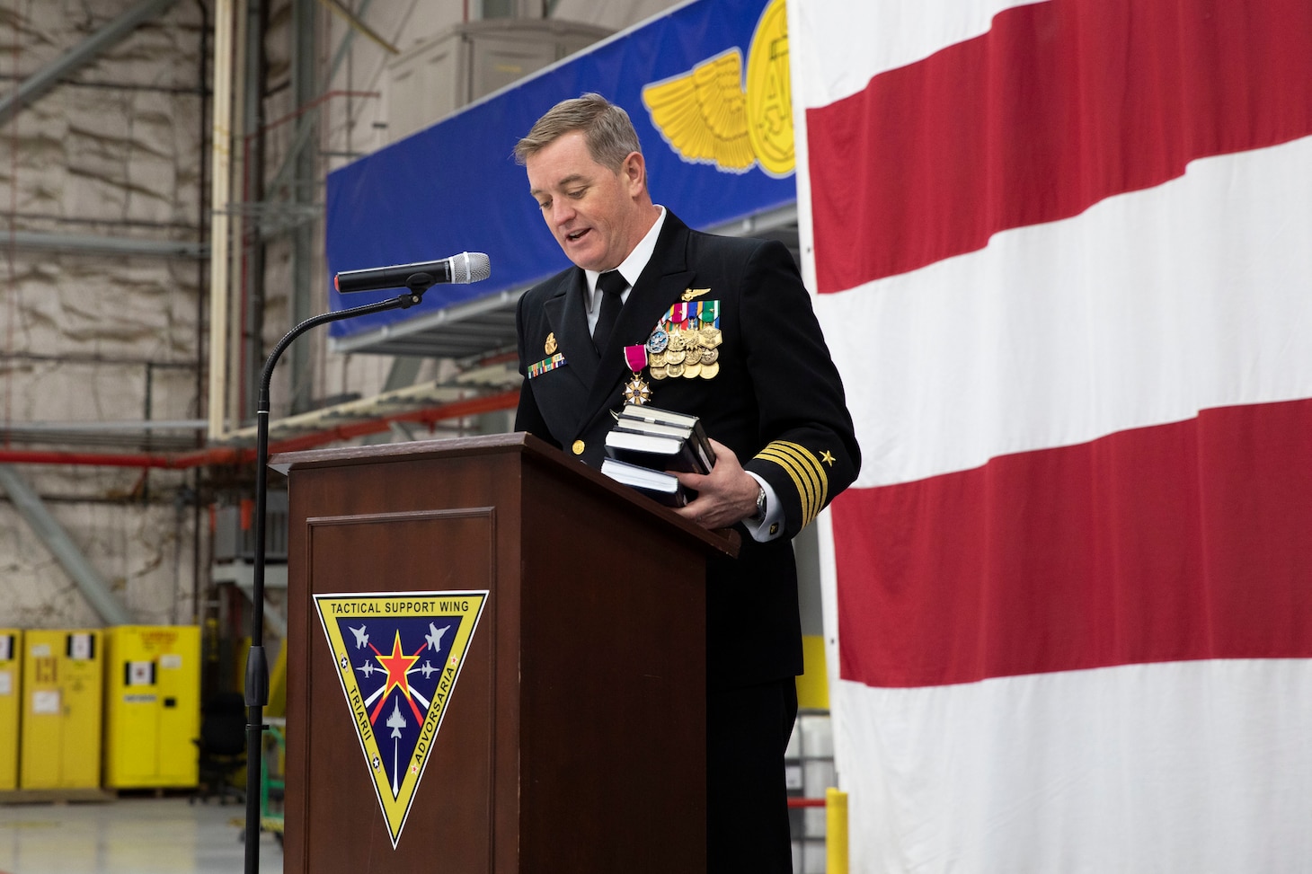 Capt. Geoffrey Hughes, Commander, Tactical Support Wing (CTSW), speaks at the CTSW change of command ceremony in the Fleet Logistics Support Wing (VR) 59 hangar at Naval Air Station Joint Reserve Base Fort Worth, Texas.