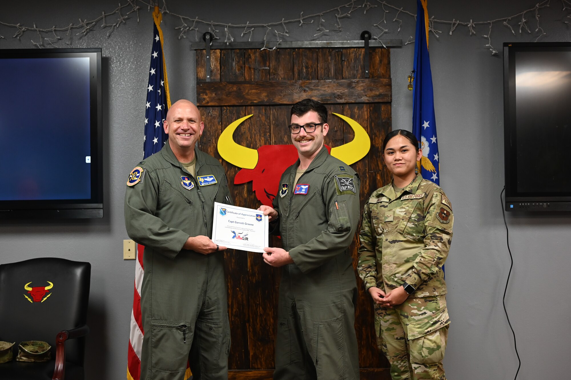 U.S. Air Force Col. Kevin Davidson (left), 47th Flying Training Wing commander, and Airman 1st Class Natalie Bait (right), 47th Force Support Squadron career development technician, present an award to Capt. Garrett Greene (middle), 85th Flying Training Squadron assistant flight commander T-38C IP, for XLer of the Week at Laughlin Air Force Base, Texas, on Feb. 22, 2023.