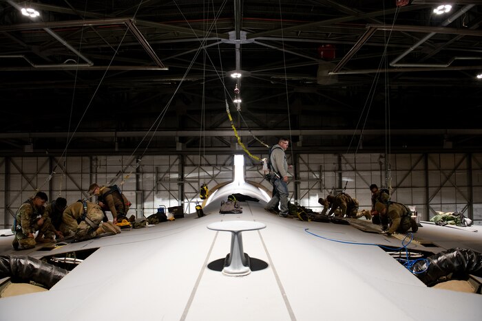 Airmen fixing an aircraft's wing