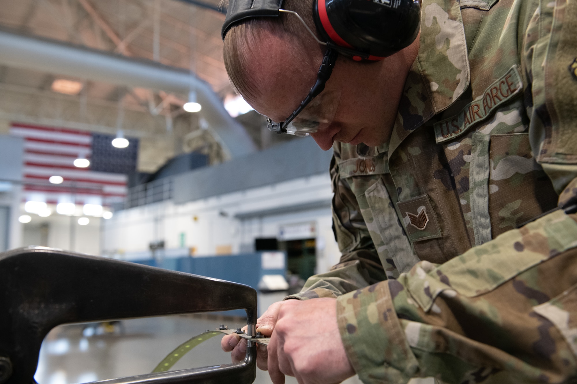 airmen working on an aircraft part