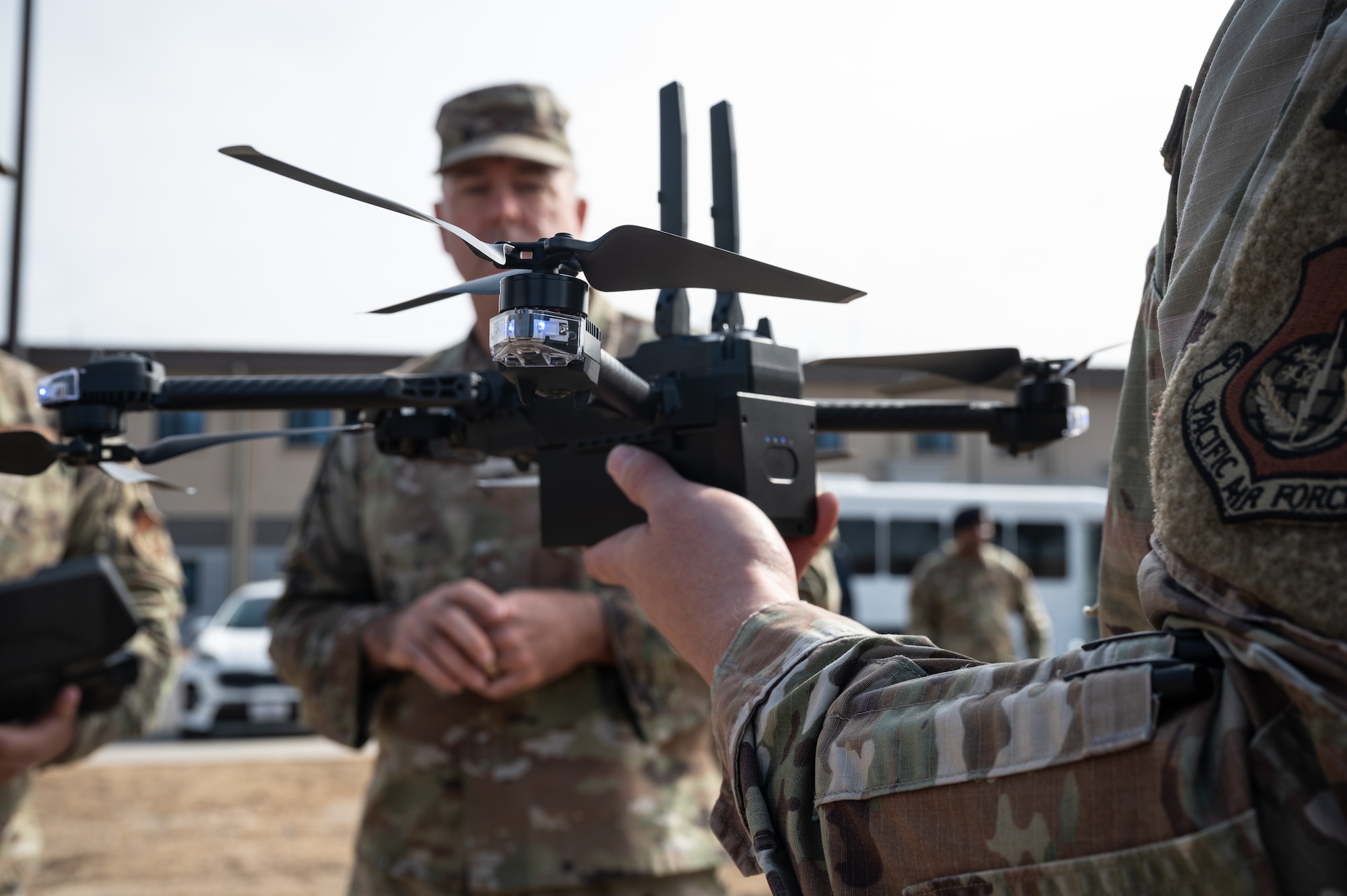 An 8th Security Forces Squadron defender holds up a small, unmanned aircraft system during Col. Patrick Miller’s, Pacific Air Forces logistics, engineering and force protection director, visit at Kunsan Air Base, Republic of Korea, Feb. 28, 2023. Miller received a capabilities demonstration to explain the benefits of investing in more sUAS qualified personnel. (U.S. Air Force photo by Staff Sgt. Sadie Colbert)