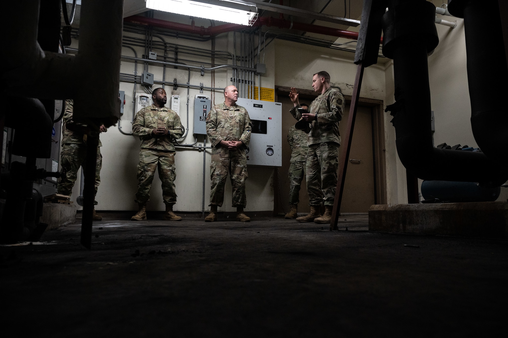 Staff Sgt. Robert Solomon (left), 8th Civil Engineer Squadron Airman dorm leader, and Col. Patrick Miller (center), Pacific Air Forces logistics, engineering and force protection director, listen to Maj. Matthew Fecke, 8th CES operations flight commander, at Kunsan Air Base, Republic of Korea, Feb. 28, 2023. While the CES squadron began larger projects, they continued to work smaller projects to ensure the whole base was tended to. (U.S. Air Force photo by Staff Sgt. Sadie Colbert)