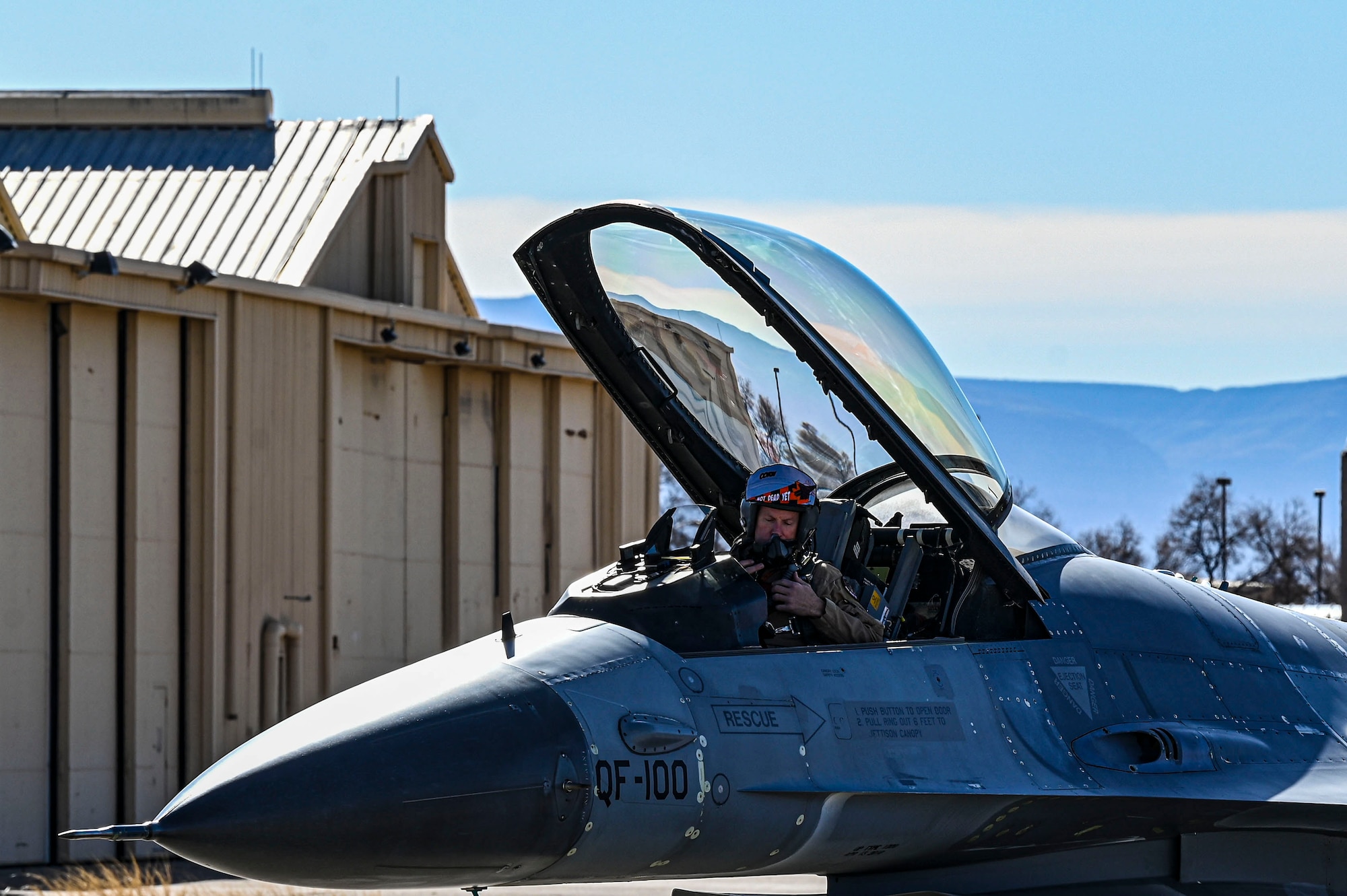 Kirk Mays, 82nd Aerial Targets Squadron Detachment 1 pilot, prepares his equipment in the cockpit of a QF-16 Viper at Holloman Air Force Base, New Mexico, Feb. 22, 2023. The detachment stationed at Holloman is a part of the 53rd Wing located at Eglin Air Force Base. (U.S. Air Force photo by Airman 1st Class Isaiah Pedrazzini)