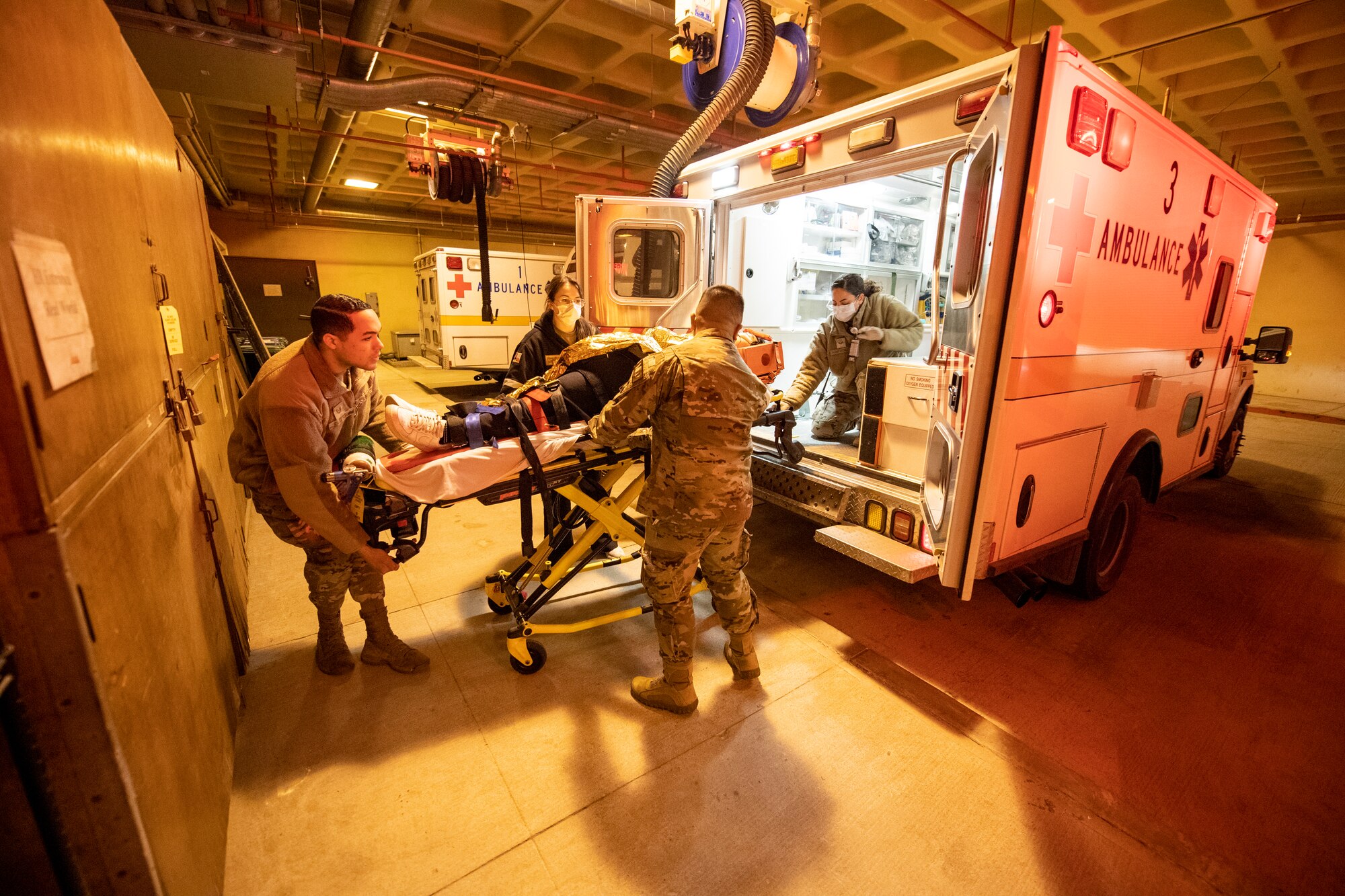 U.S. Air Force Airmen from the 51st Medical Group (MDG) unload Kwang Pil Pak, 51st MDG warrior medicine clinic administrator and simulated trauma patient, from the back of an ambulance at the urgent care facility on Osan Air Base, Republic of Korea, Feb. 28, 2023.  The training event tested the Airmen’s ability to quickly transport patients from the field to the urgent care facility. (U.S. Air Force photo by Airman 1st Class Aaron Edwards)