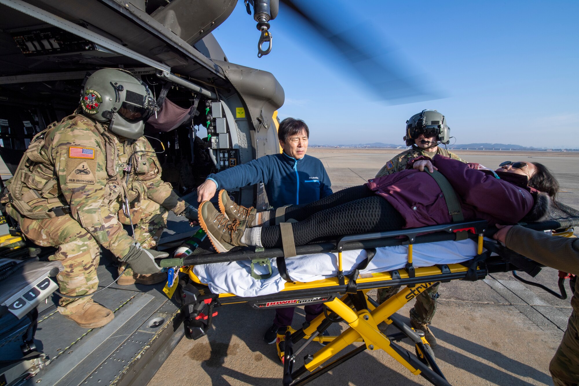 U.S. Army Spc. Noah Quevedo, 3-2 General Support Aviation Battalion crew chief, left, and Staff Sgt. Michael Mongia, 32nd GSAB flight paramedic, right, load U.S. Air Force Master Sgt. Maria Szymanski, 51st Medical Group urgent care flight chief and simulated trauma patient, into a HH-60M BlackHawk at Osan Air Base, Republic of Korea, Feb. 28, 2023. After loading, the patient was transported to the ROK Armed Forces Trauma Center for further treatment. The training enabled U.S. and ROK service members to strengthen interoperability while responding to emergency situations. (U.S. Air Force photo by Airman 1st Class Aaron Edwards)