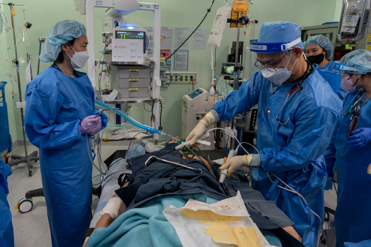 Republic of Korea Armed Forces Trauma Center (AFTC) personnel defibrillate Kwang Pil Pak, 51st Medical Group warrior medicine clinic administrator and simulated trauma patient, at the AFTC, Republic of Korea, Feb. 28, 2023. The patient was a victim of multiple stab wounds and was medically evacuated to the center from Osan Air Base, where the simulated emergency originated. (U.S. Air Force photo by Airman 1st Class Aaron Edwards)