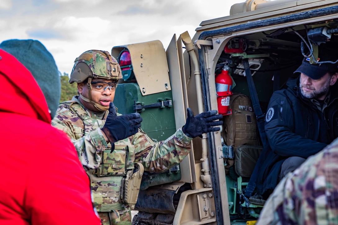 A military officer speaks to a group of people.