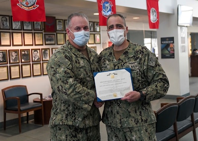 U.S. Navy Commander David Bennett, deputy director for Naval Medical Center Camp Lejeune Branch Clinics, left, was recognized for his heroic actions that saved a life.