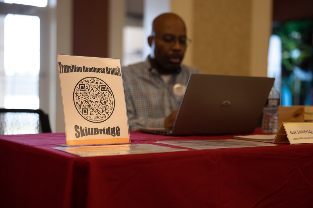 A Transition Readiness Program sign stands at a Marine Corps Community Services Lejeune-New River booth during a SkillBridge expo at Marston Pavilion on Marine Corps Base Camp Lejeune, North Carolina, Feb. 28, 2023. The expo was held to help service members that are in their last 180 days of service explore different specific industry training, apprenticeships and internship opportunities through the SkillBridge program. (U.S. Marine Corps photo by Cpl. Antonino Mazzamuto)