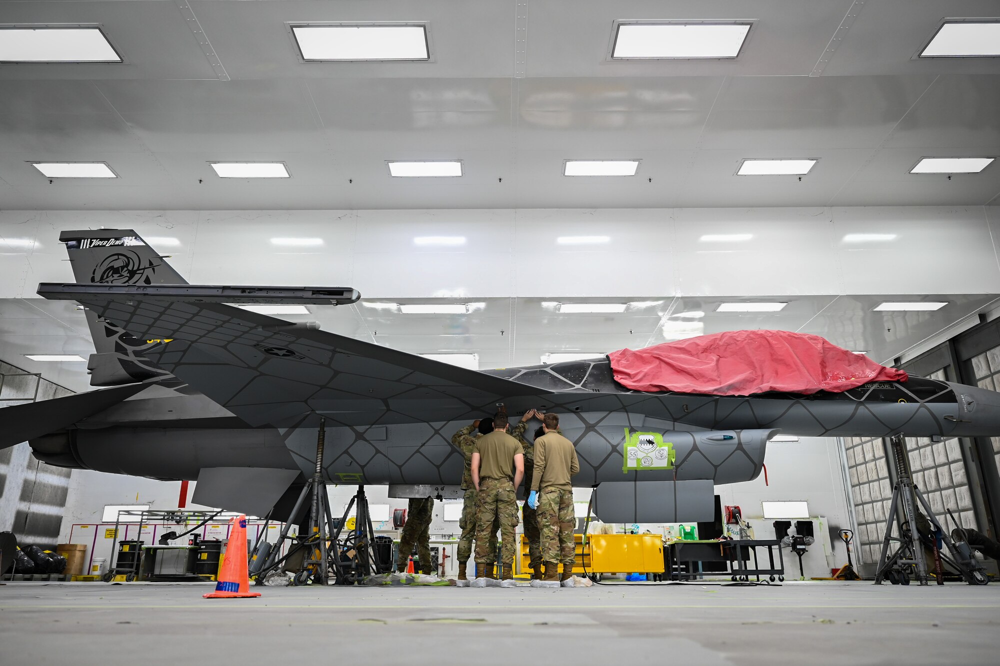 U.S. Air Force Airmen prepare to paint an F-16C Fighting Falcon