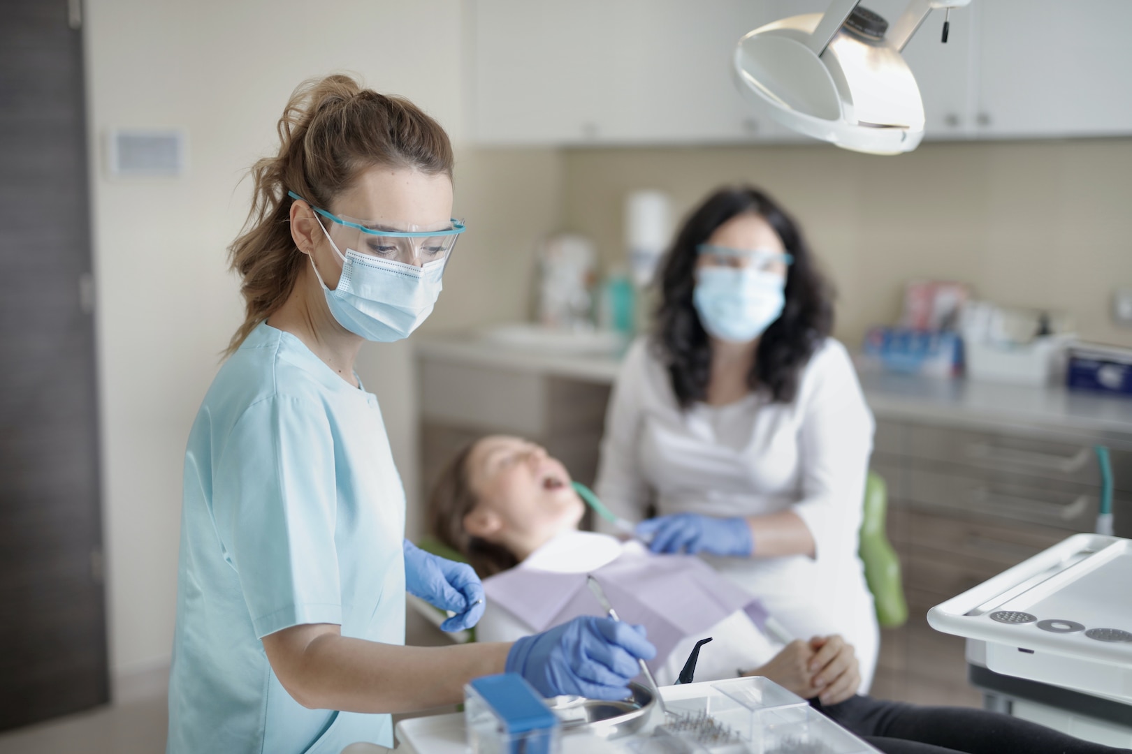 A dentist and hygenist work on a patient