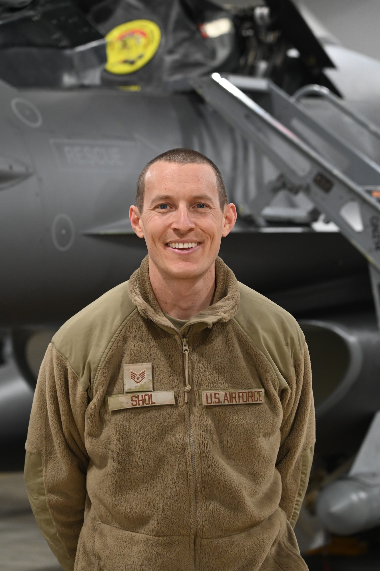 U.S. Air National Guard tactical aircraft maintenance specialist, Staff Sgt. Paul Shol, poses for a photo in front of an F-16 Fighting Falcon assigned to the 148th Fighter Wing, Minnesota Air National Guard, on February 04, 2023. Shol is one of seven airmen assigned to the 148th Fighter Wing who earned the highest possible ASVAB AFQT score of 99.