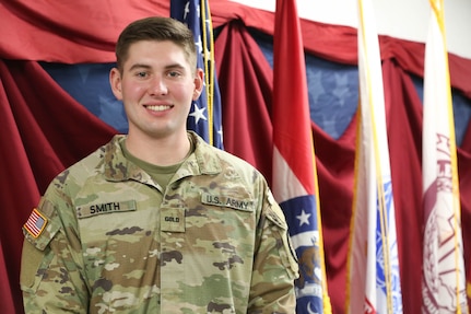 Officer Candidate Andrew Smith, a Soldier assigned to the 1138th Engineer Co., stands in front of a flag display at the College of the Ozarks William S. Knight (WSK) Center for Patriotic Education, Point Lookout, Mo., Nov. 18, 2022. Smith is also an Officer Candidate with College of the Ozarks Bobcat Guard Officer Leadership Development (GOLD) Program (Photo by U.S. Army National Guard Spc. Rose Di Trolio).