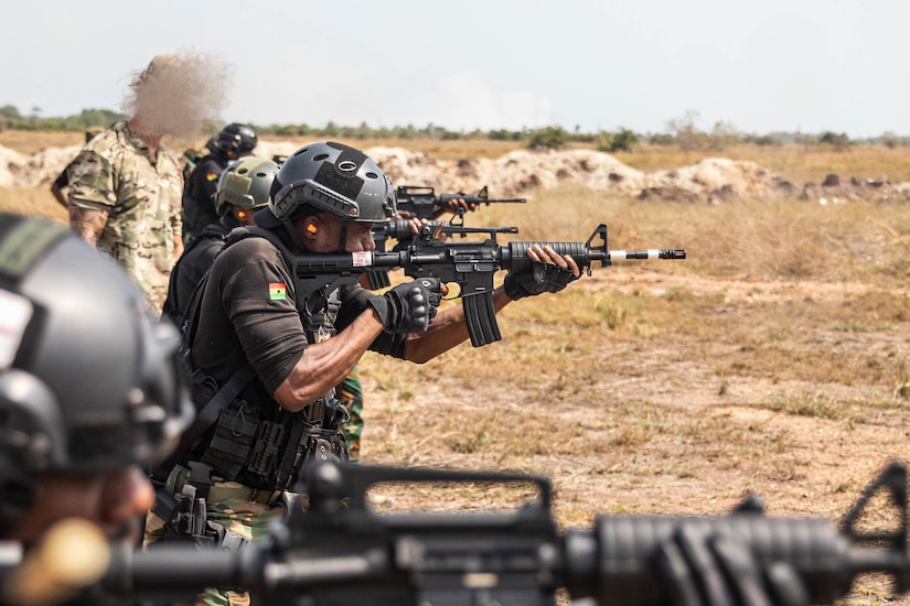 Soldiers fire rifles on a range.