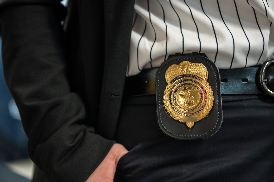 A person is displaying their badge.