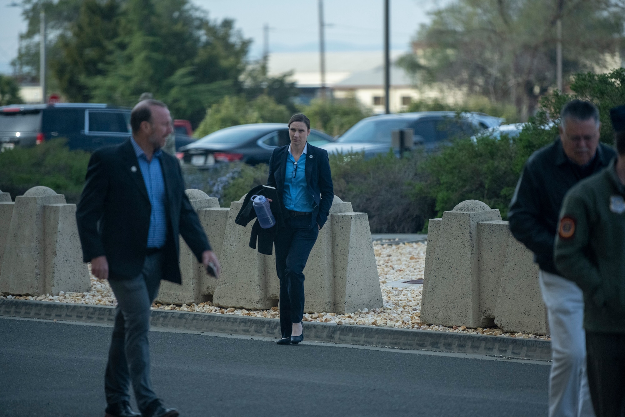 A person wearing a suit walks across the street.