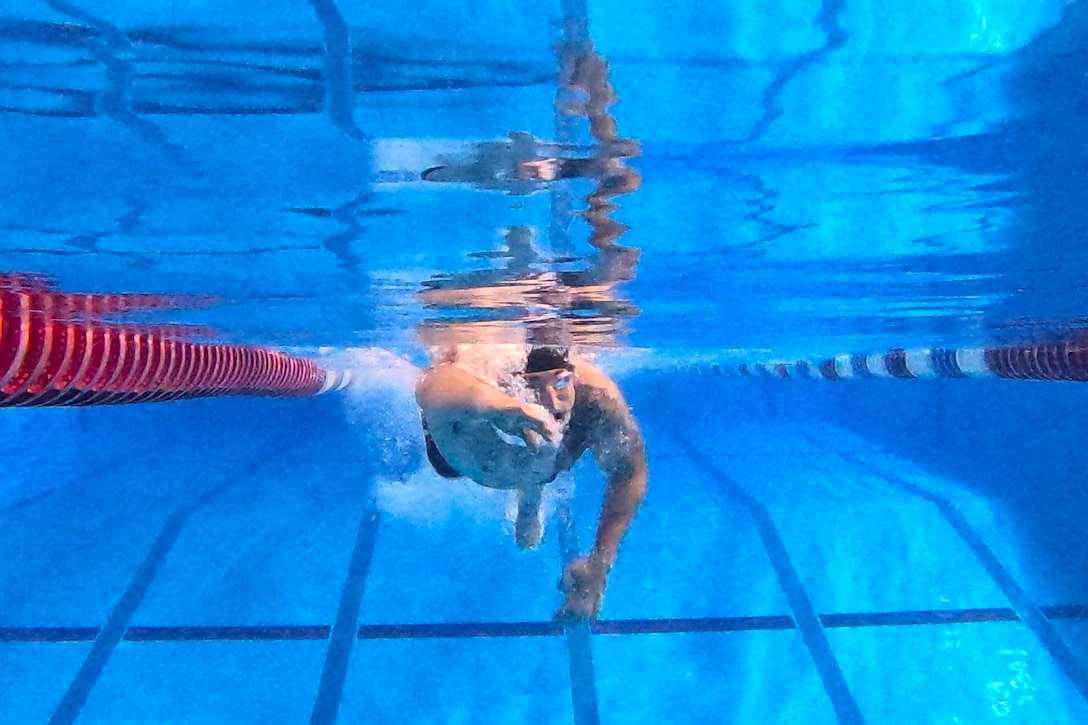 A competitor  swims a lap in a pool.