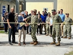 people stand around as a ribbon is cut