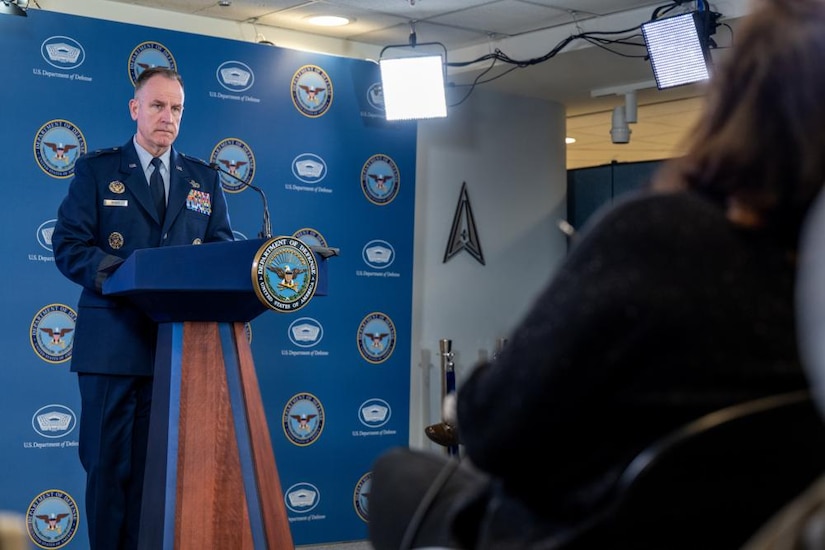 A man in a uniform briefs members of the media.