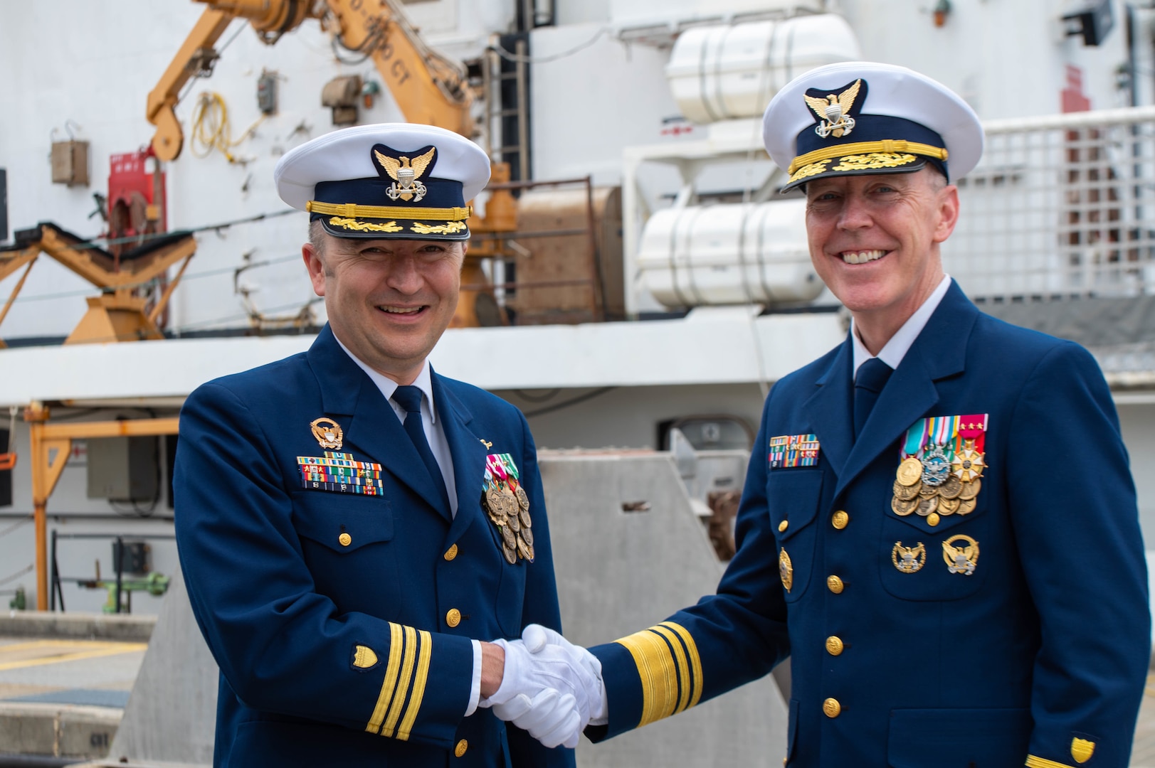 Vice Adm. Kevin Lunday, commander, Coast Guard Atlantic Area (right), shakes hands with Cmdr. Aaron W. Delano-Johnson, commanding officer of Coast Guard Cutter Decisive (left), during the Decisive’s decommissioning ceremony at Pensacola, Florida, March 2, 2023. Decisive is the third Coast Guard 210-foot, Reliance-class medium endurance cutter to be decommissioned since 2001 as part of modernization efforts across the fleet. (U.S. Coast Guard photo by Petty Officer 2nd Class Jose Hernandez)