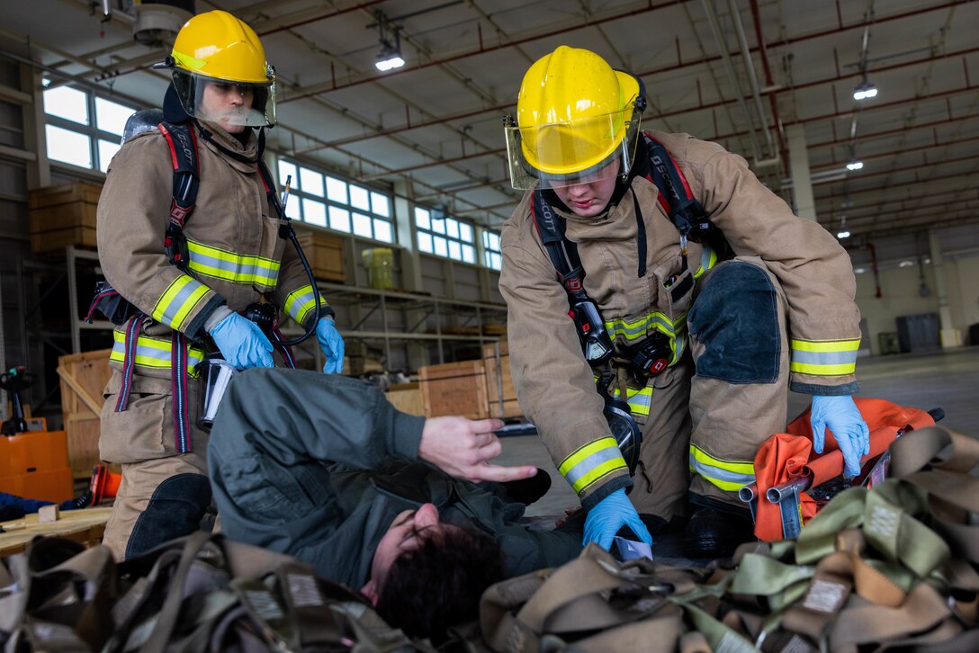 2023年2月10日、米海兵隊岩国航空基地で実施された緊急対応訓練において模擬負傷者を救助する、第12海兵飛行大隊（MAG-12）、第171海兵師団支援中隊（MWSS-171）所属の航空機救難消防隊（ARFF）員のウェスリー・トンプキンス兵長（左）とシャイロ・バークハート伍長（右）。この訓練はARFF所属の海兵隊員が年に一度の必須訓練で、実際のシナリオに備えるため、基地内での大規模災害対応時の即応態勢と効率を高める目的で岩国地区消防組合の消防救急隊員と協力して実施している。（写真：アイザック・オロスコ伍長）