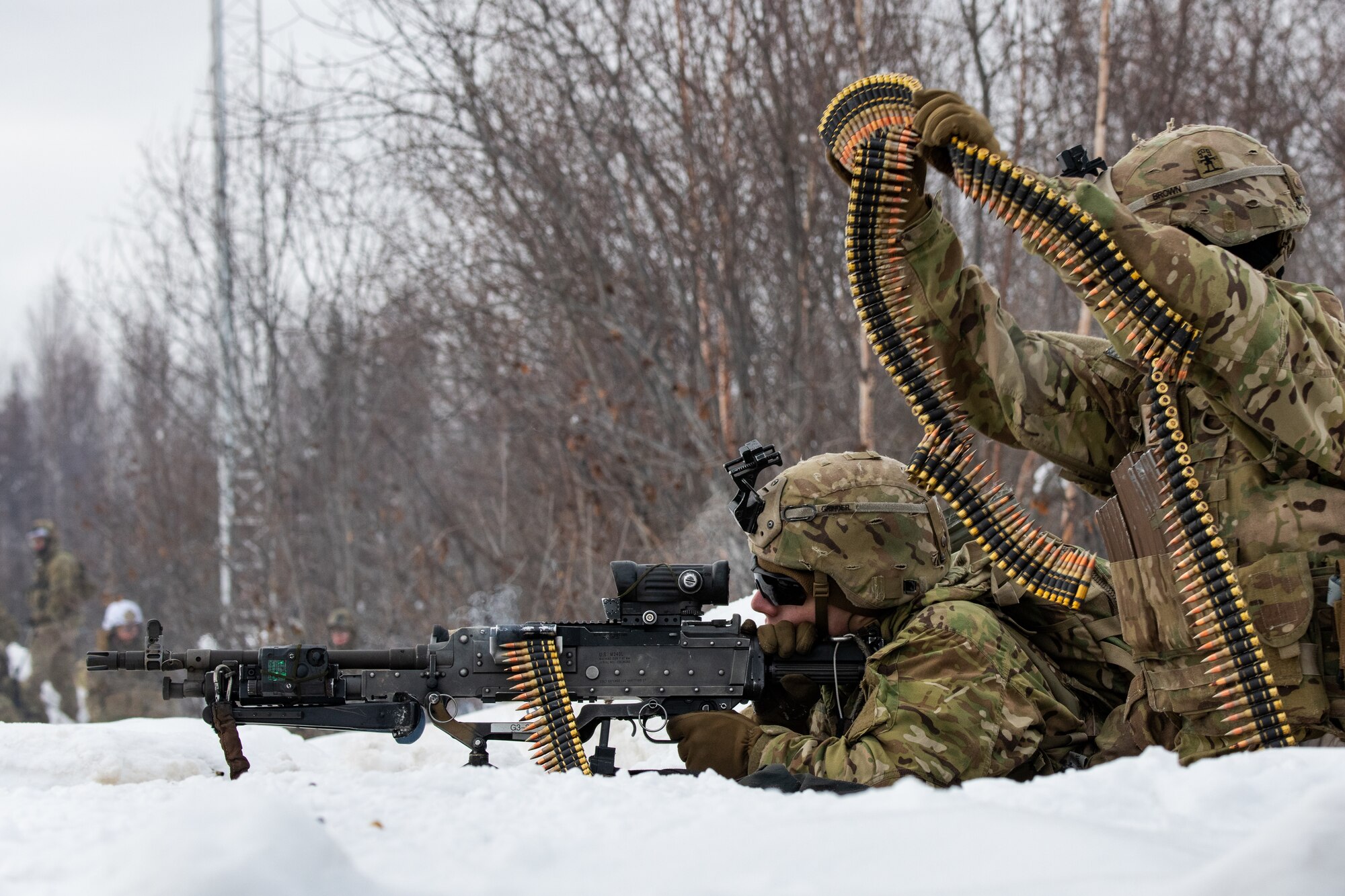A photo of two soldiers manning a defensive position and firing a machine gun