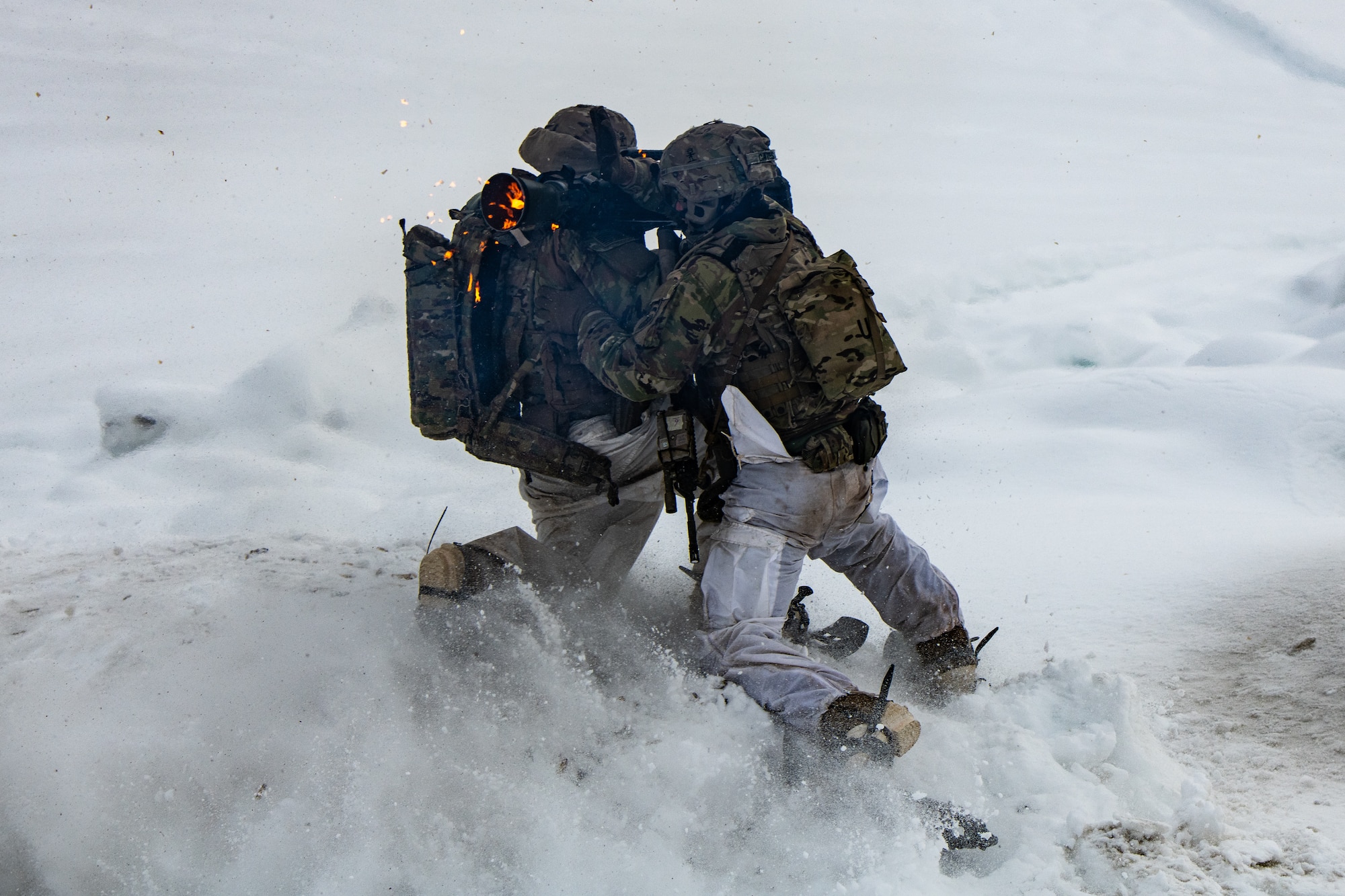 A photo of soldiers bracing against the back blast from a rocket firing