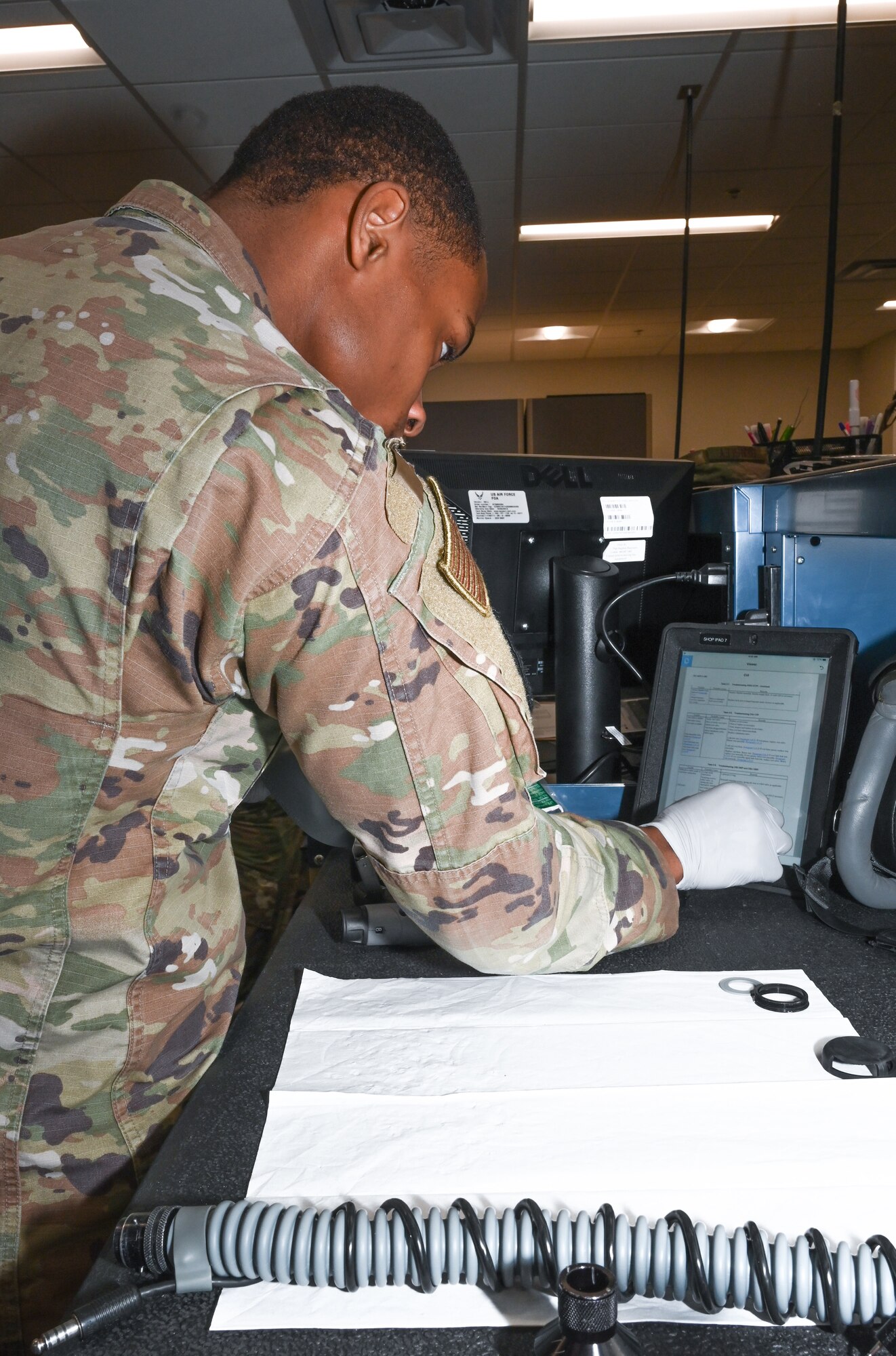 Senior Airman Anthony Ratliff, Aircrew Flight Equipment journeyman, assigned to the 509th Operations Support Squadron, follows along with the technical order for tearing down, inspecting, cleaning, reassembling, and testing the helmets and oxygen masks at Whiteman Air Force Base, Missouri, Feb. 13, 2023. The technical order provides step by step instructions on how to perform the task. (U.S. Air Force photo by Airman 1st Class Hailey Farrell)