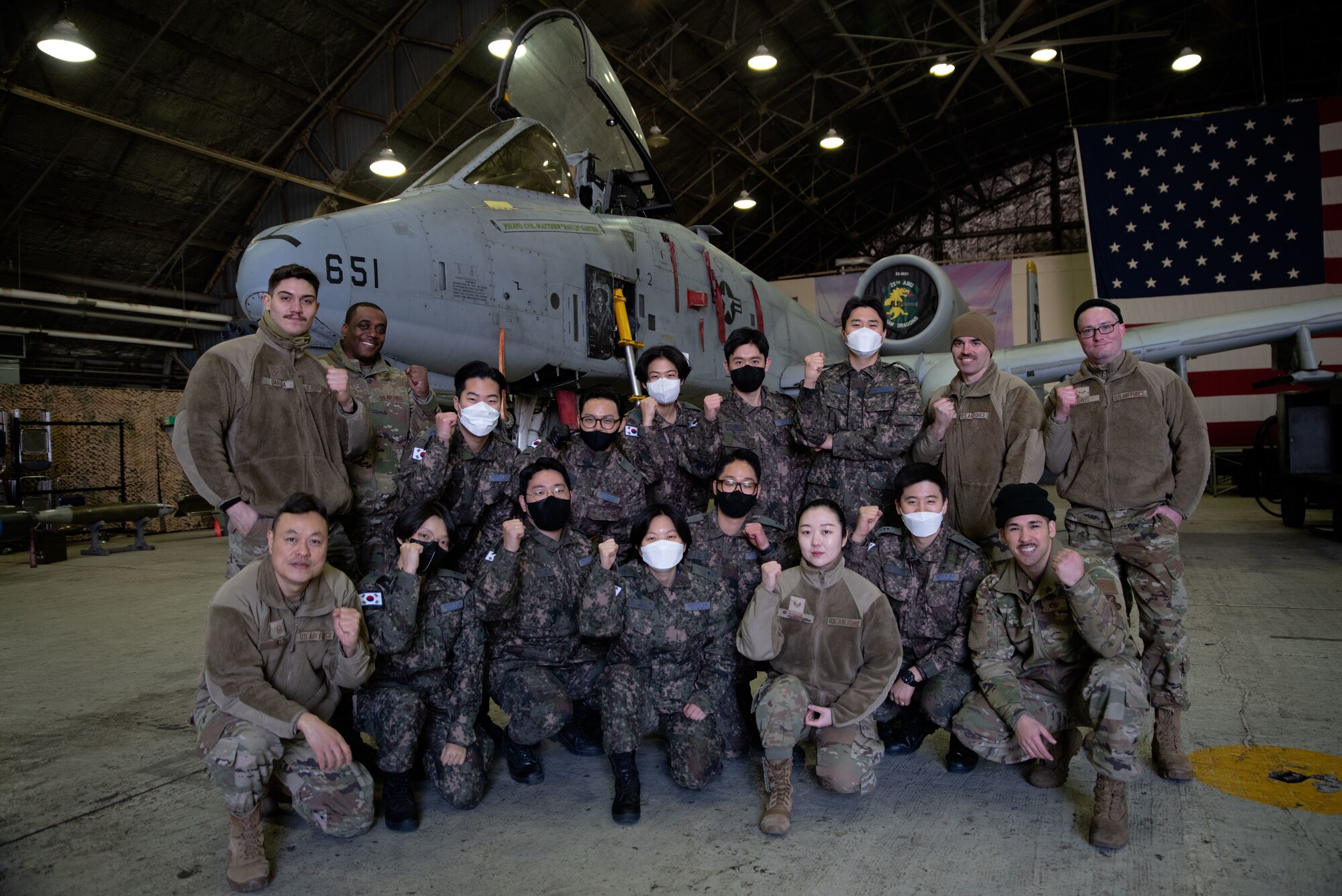 51st Maintenance Group Airmen and Republic of Korea Air Force interpretation officers in training pose for a group photo during an immersion tour at Osan Air Base, ROK, Feb. 23, 2023.