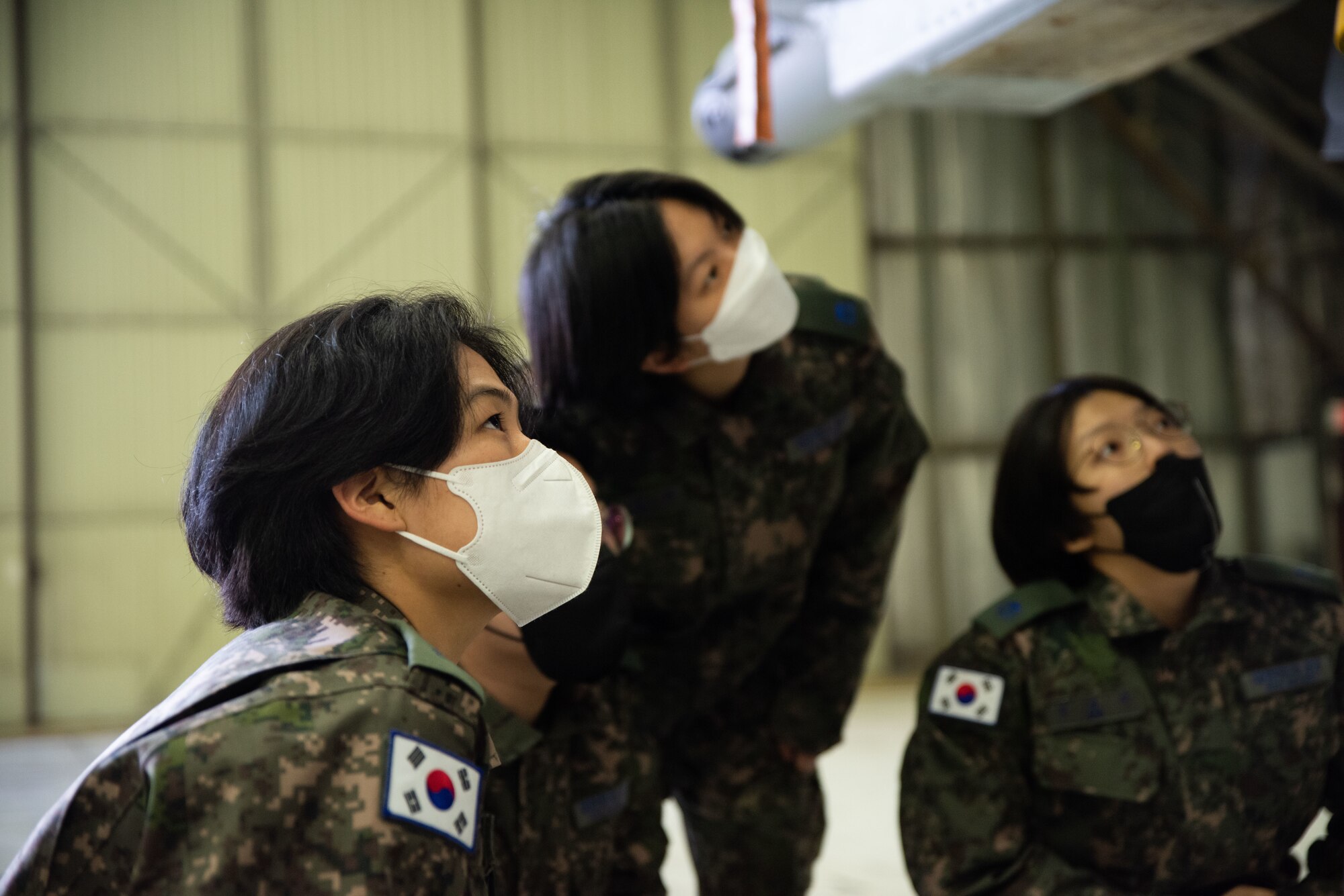 Republic of Korea Air Force interpretation officers in training look up into the gun bay of an A-10C Thunderbolt II during an immersion tour at Osan Air Base, ROK, Feb. 23, 2023.