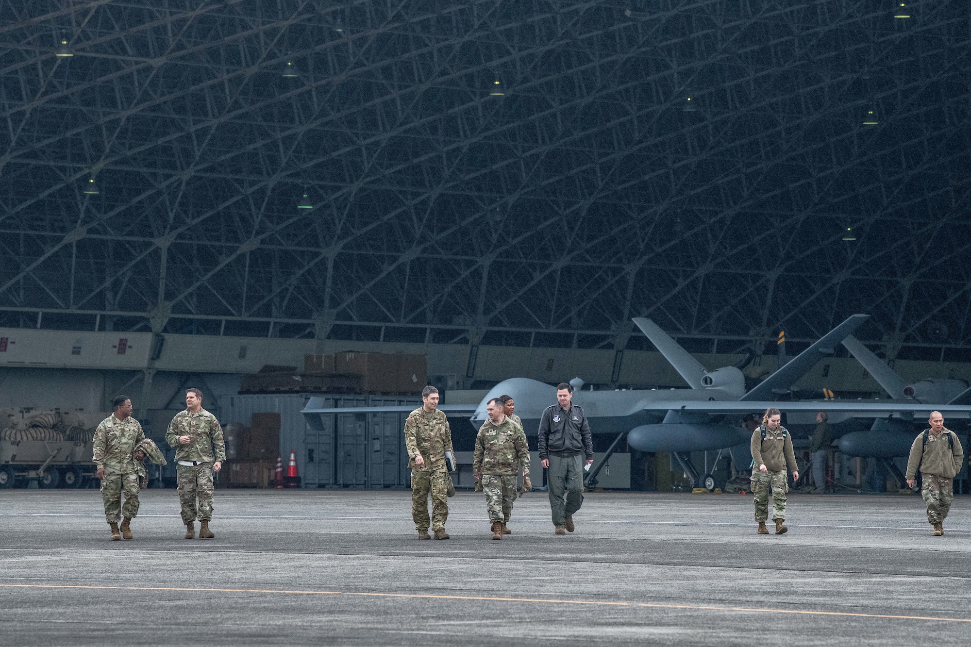 Airmen walk in front of MQ-9 Reaper aircraft