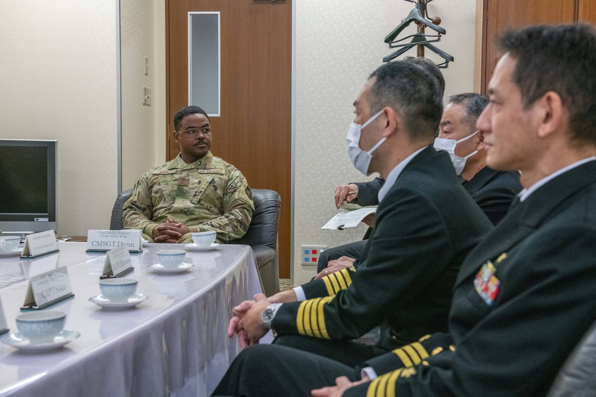 A U.S. Air Force Chief Master Sergeant sits with members of Japan Maritime Self-Defense Force