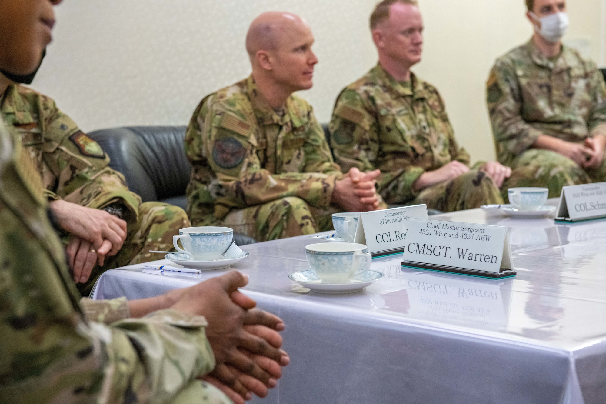 A nameplate sits on a table during a meeting