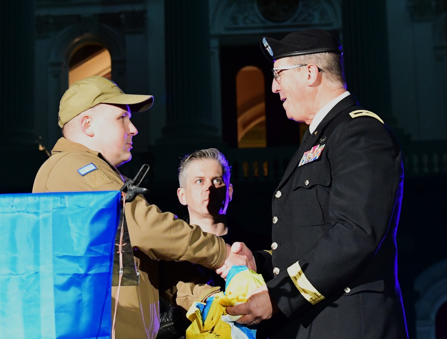A double-amputee Ukrainian soldier presents a Ukrainian flag signed by fellow Ukrainian soldiers to Maj. Gen. Matthew P. Beevers, acting adjutant general of the California National Guard, in Sacramento, California, Feb. 24, 2023.