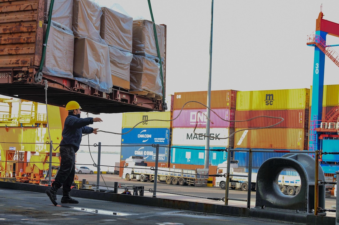 A sailor throws a line during the  delivery of  relief supplies.