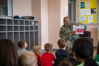 Capt. David Adams reads to children on National Read Across America Day.