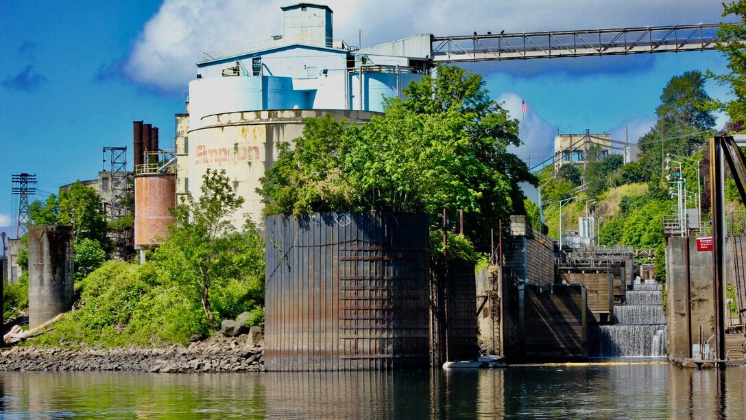 A view of an industrial-looking setting with a four-level navigation canal off to the right side on a sunny day