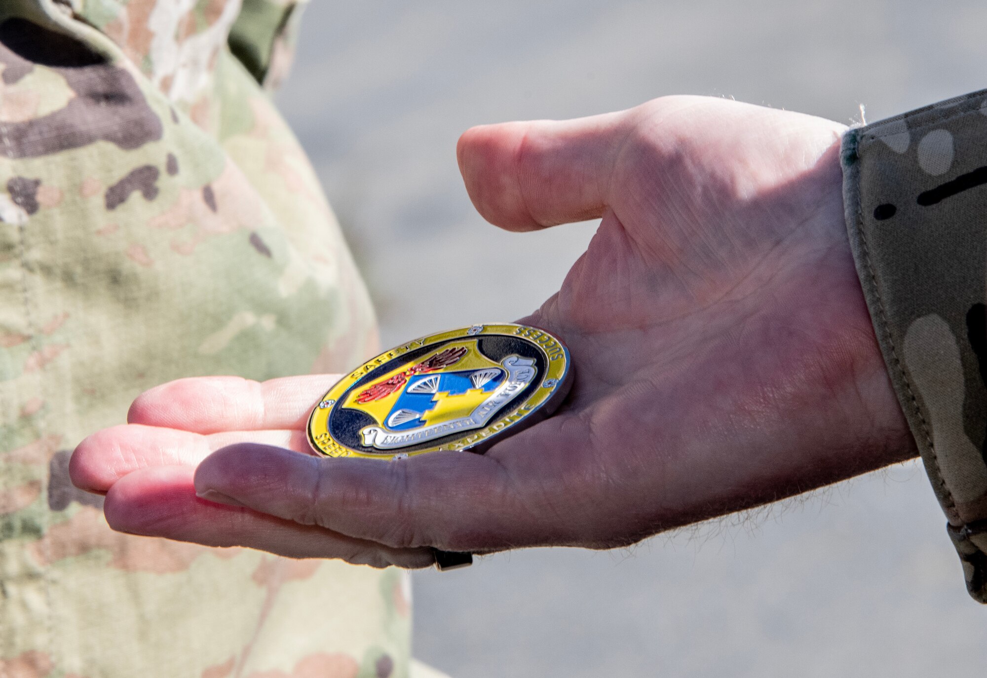 A hand holds a presentation coin