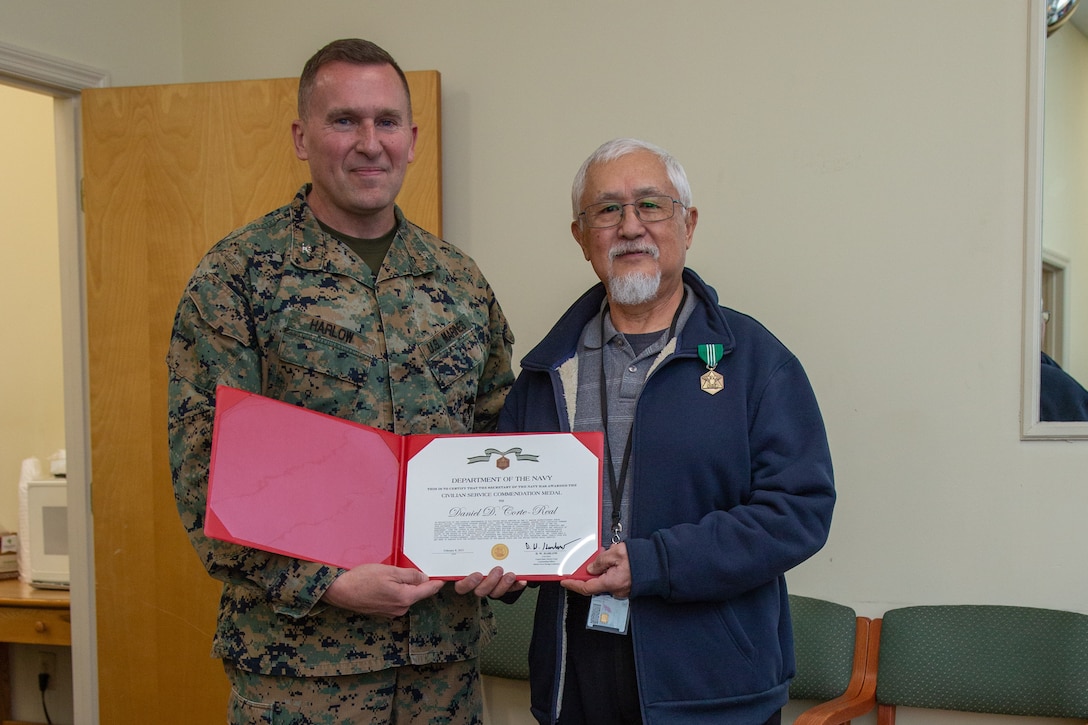 U.S. Marine Corps Col. Donald Harlow, left, commanding officer, Marine Force Storage Command, Marine Corps Logistics Command, and Dan Corte-Real, right, regional project manager for the Consolidated Storage Program, II MEF Logistics Command, pose for a photo during a retirement ceremony at the Individual Issue Facility on Marine Corps Base Camp Lejeune, North Carolina, Feb. 8, 2023. Corte-Real retired with 54 years of dedicated service between active duty with the U.S. Navy and U.S. Marine Corps and civilian service with the Department of Defense. (U.S. Marine Corps photo by Sgt. Ginnie Lee)