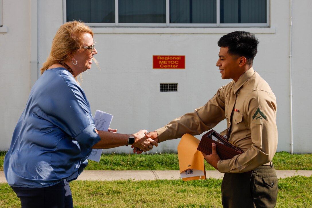 Marine Corps Air Station (MCAS) Cherry Point Commanding Officer U.S. Marine Corps Col. Brendan Burks, left, congratulates U.S. Marine Corps Lance Cpl. Miguel Romero, an air traffic controller with Headquarters and Headquarters Squadron, Marine Corps Air Station (MCAS) Cherry Point, right, at the Air Traffic Control Tower, MCAS Cherry Point, North Carolina, Feb. 24, 2023. Romero, a Faribault, Minnesota native, was recognized as the Service Person of the Quarter by the Carteret County Chamber of Commerce Military Affairs Committee for his volunteer work in the local community and on the air station. (U.S. Marine Corps photo by Lance Cpl. Lauralle Walker)