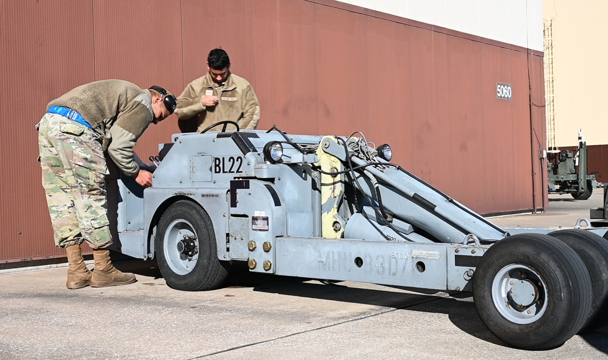Senior Airman Jesse Papenhausen and Airman 1st Class Toby Rodriguez, 509th Aircraft Maintenance Squadron, weapons load crew members, prepare a jammer to be driven at Whiteman Air Force Base, Missouri, Feb. 2, 2023. The jammer is used to install a smart bomb rack assembly. (U.S. Air Force photo by Airman 1st Class Hailey Farrell)