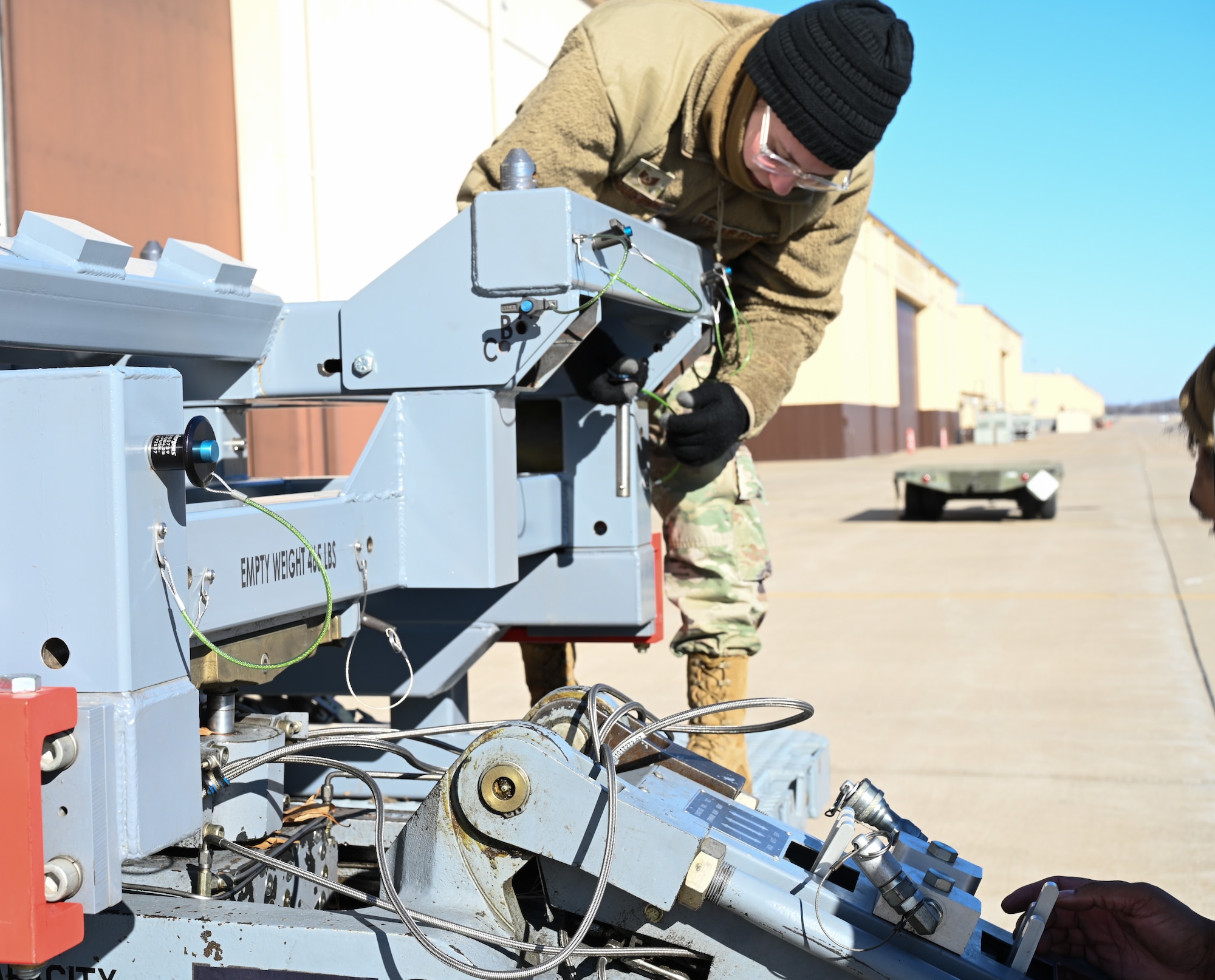 Technical Sgt. Kylie Boucher, 509th Aircraft Maintenance Squadron, weapon expeditor, helps attach the jammer to the launcher loading system (LLS) adapter at Whiteman Air Force Base, Missouri, Feb. 2, 2023. Using the LLS streamlines the reconfiguration capabilities by reducing the man hours and equipment used to load. (U.S. Air Force photo by Airman 1st Class Hailey Farrell)